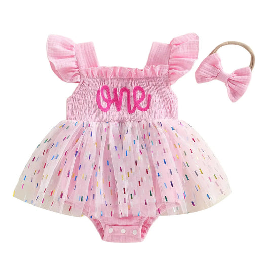 Baby girl 1st birthday pink confetti tutu romper outfit paired with a matching bow headband.