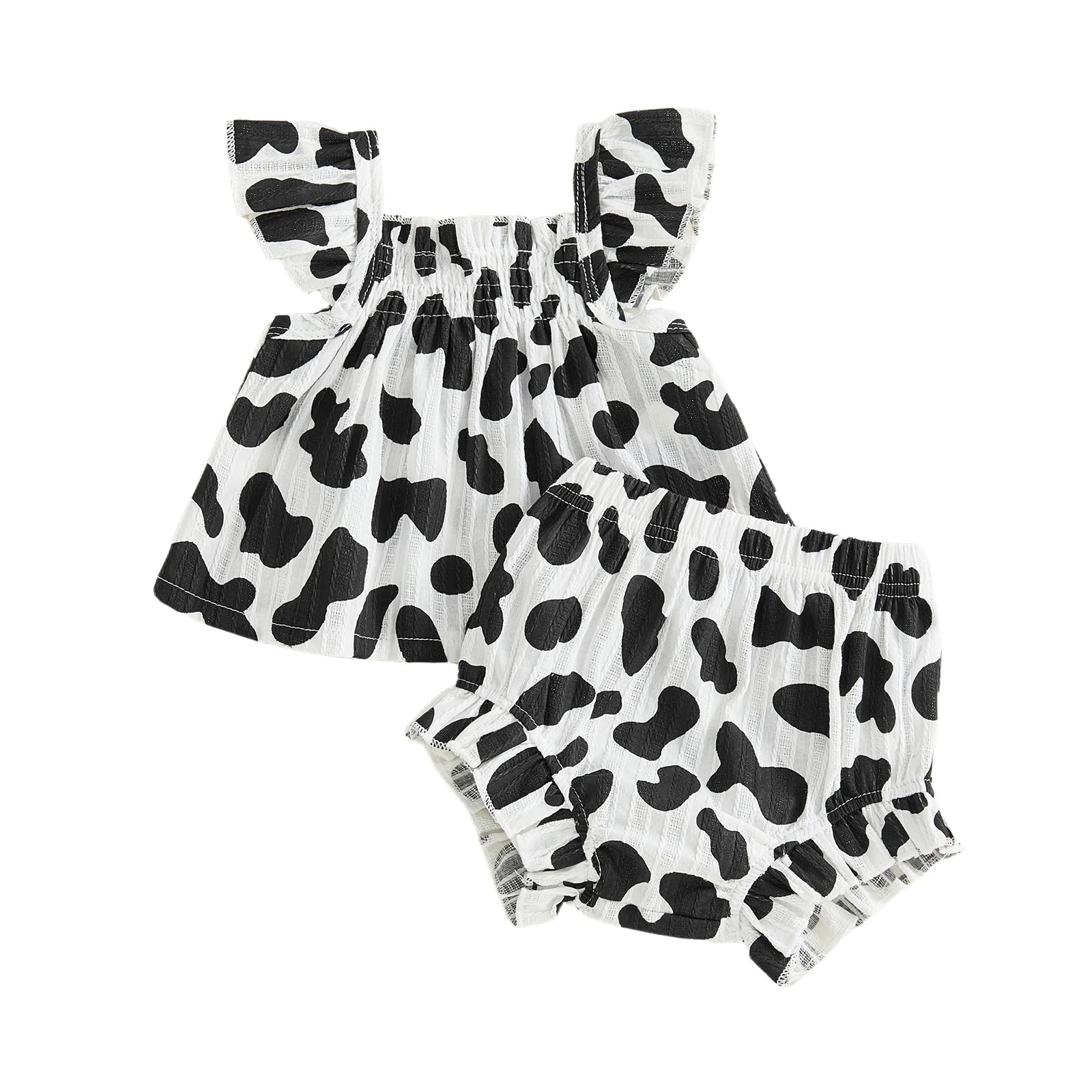 Isolated flat lay of the black and white cow print baby girl two-piece summer set showing the top and shorts.