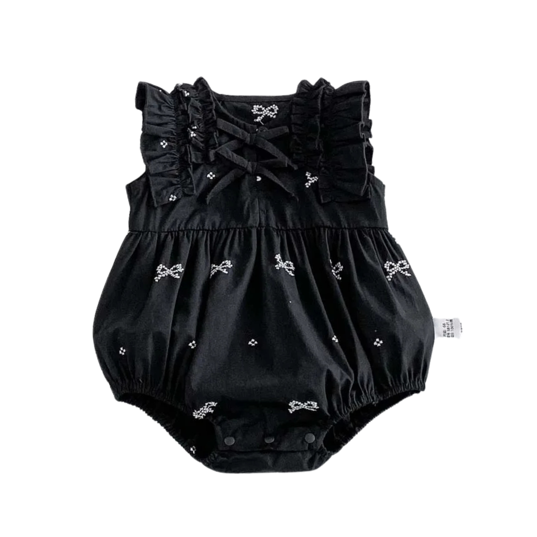 Front view of a black and white baby girl bubble romper with embroidered bows and ruffle sleeves on a white background.