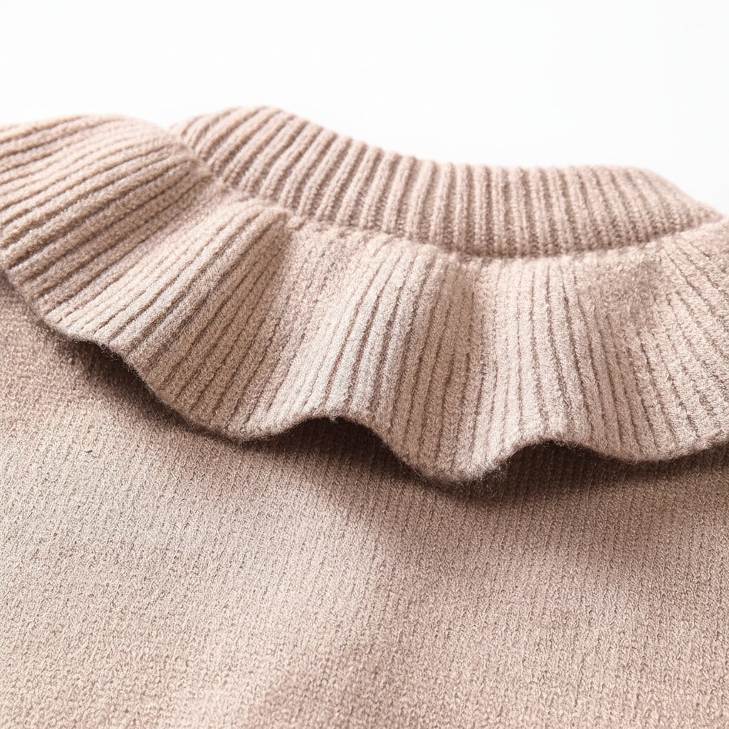 Close-up of the wide ribbed ruffle collar and white button-front closure on a taupe baby cardigan sweater.
