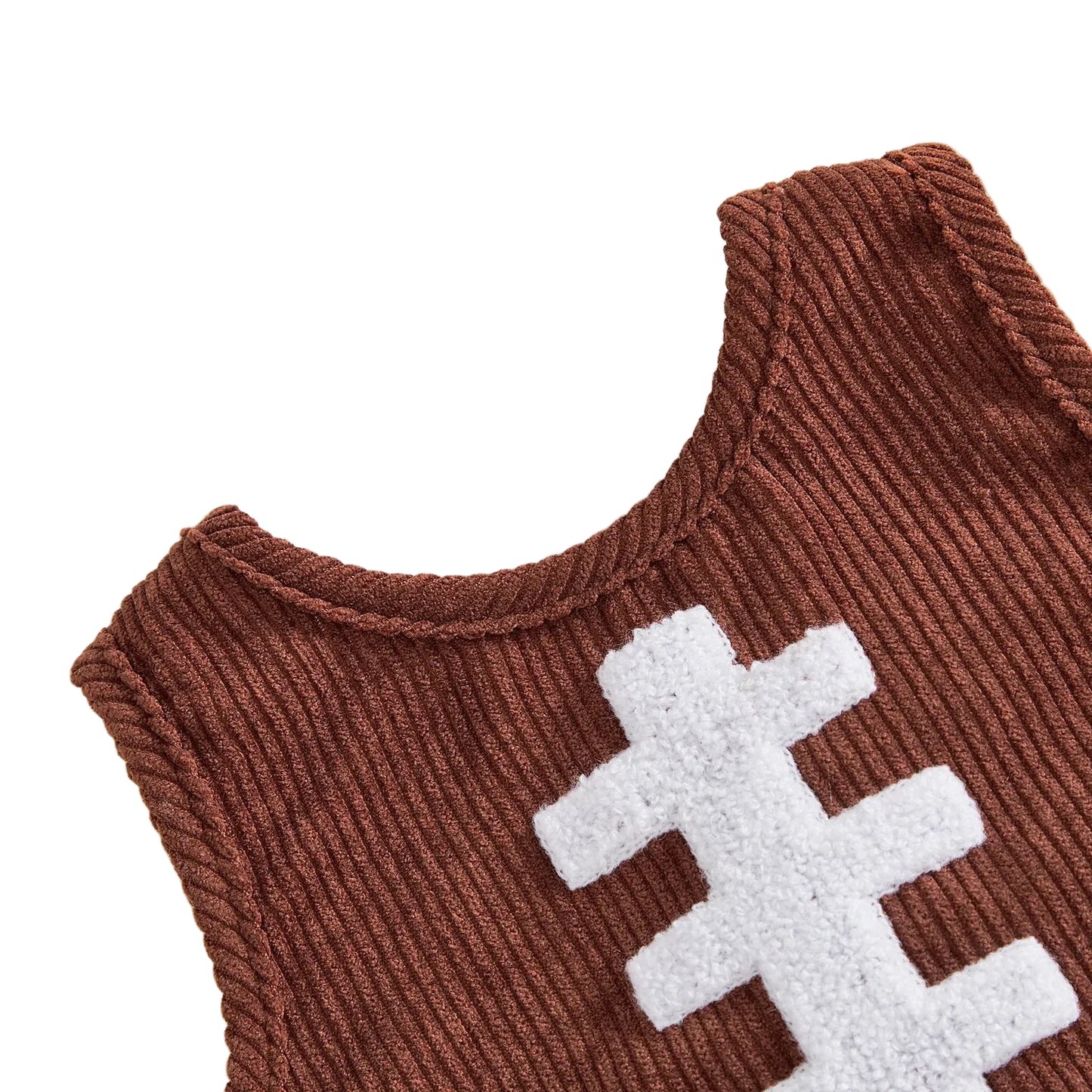Close-up of plush white towel embroidered football laces on brown corduroy baby top