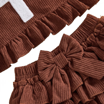 Close-up of front decorative bow and tiered ruffles on brown corduroy baby shorts