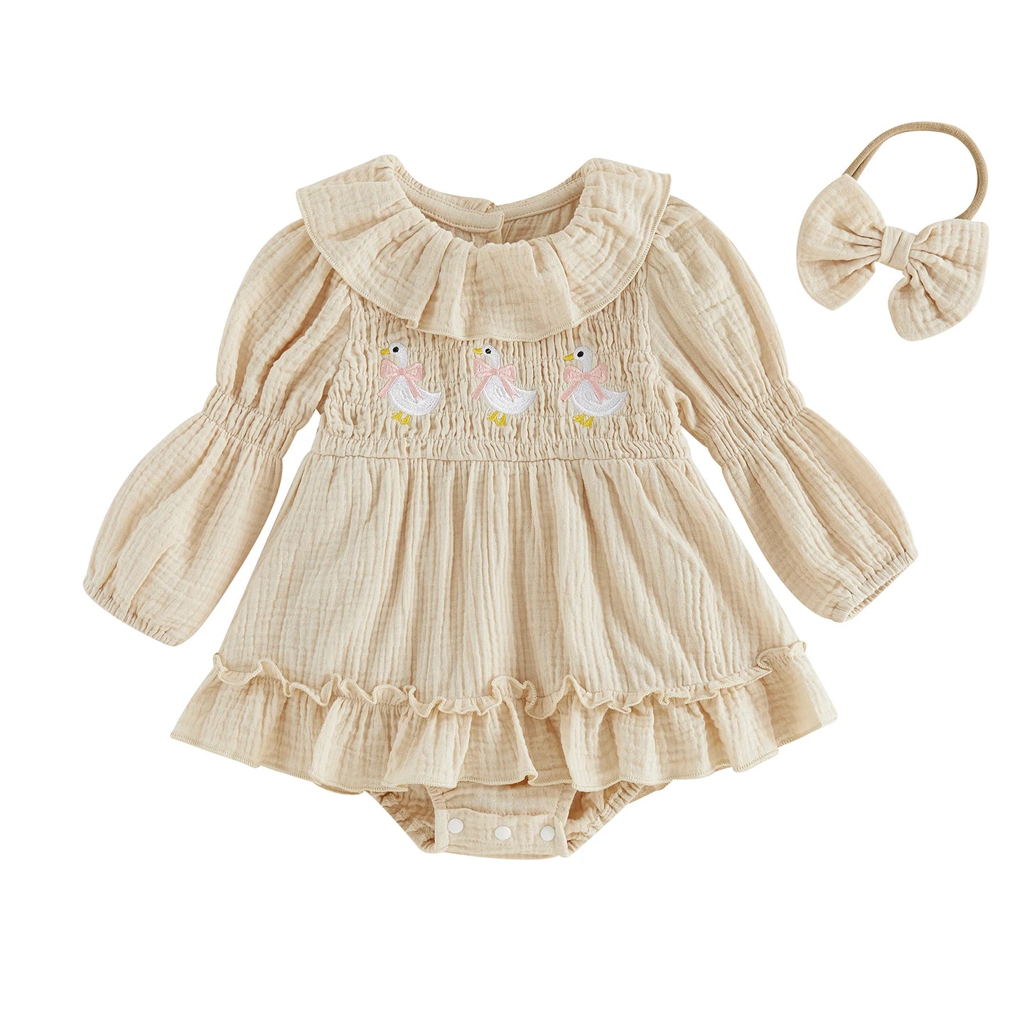 Front view of a baby girl cream long-sleeve smocked romper dress with goose embroidery and a matching bow headband on a white background.