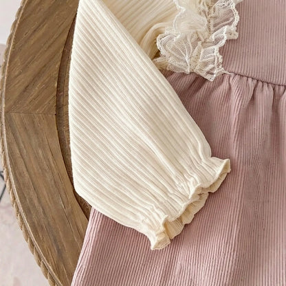 Close-up of the elastic ruffled wrist cuff on the cream ribbed long-sleeve baby top