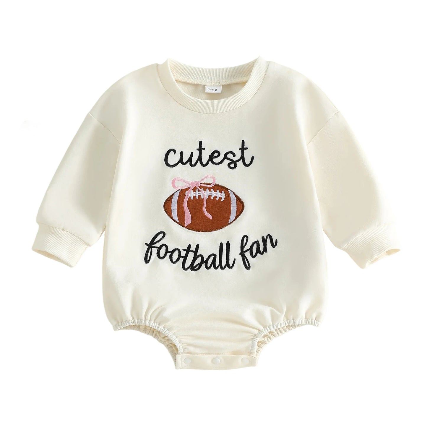 Cream Baby Girl "Cutest Football Fan" Long Sleeve Bubble Romper featuring an embroidered football with a pink bow on a white background.
