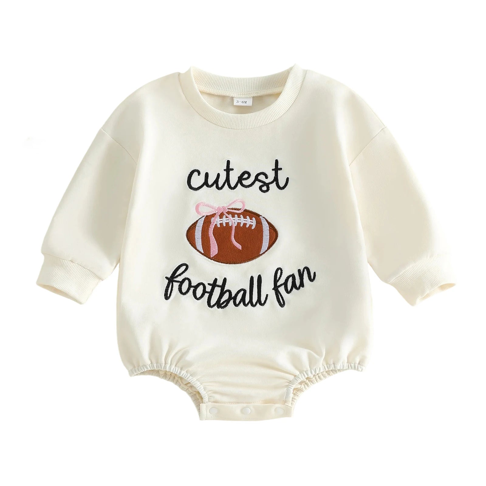 Cream Baby Girl "Cutest Football Fan" Long Sleeve Bubble Romper featuring an embroidered football with a pink bow on a white background.