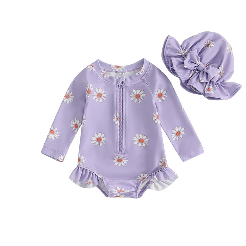 Lavender purple baby girl one-piece long sleeve swimsuit featuring white daisy print and a matching purple ruffle sun hat.