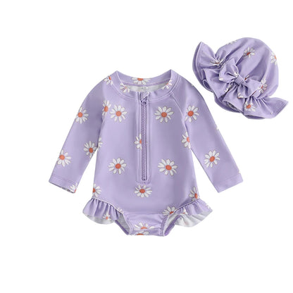 Lavender purple baby girl one-piece long sleeve swimsuit featuring white daisy print and a matching purple ruffle sun hat.