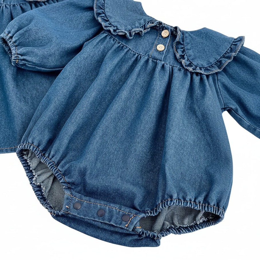 Close-up of the baby girl blue denim long-sleeve romper highlighting the gathered roomy bodice and elastic balloon cuffs.