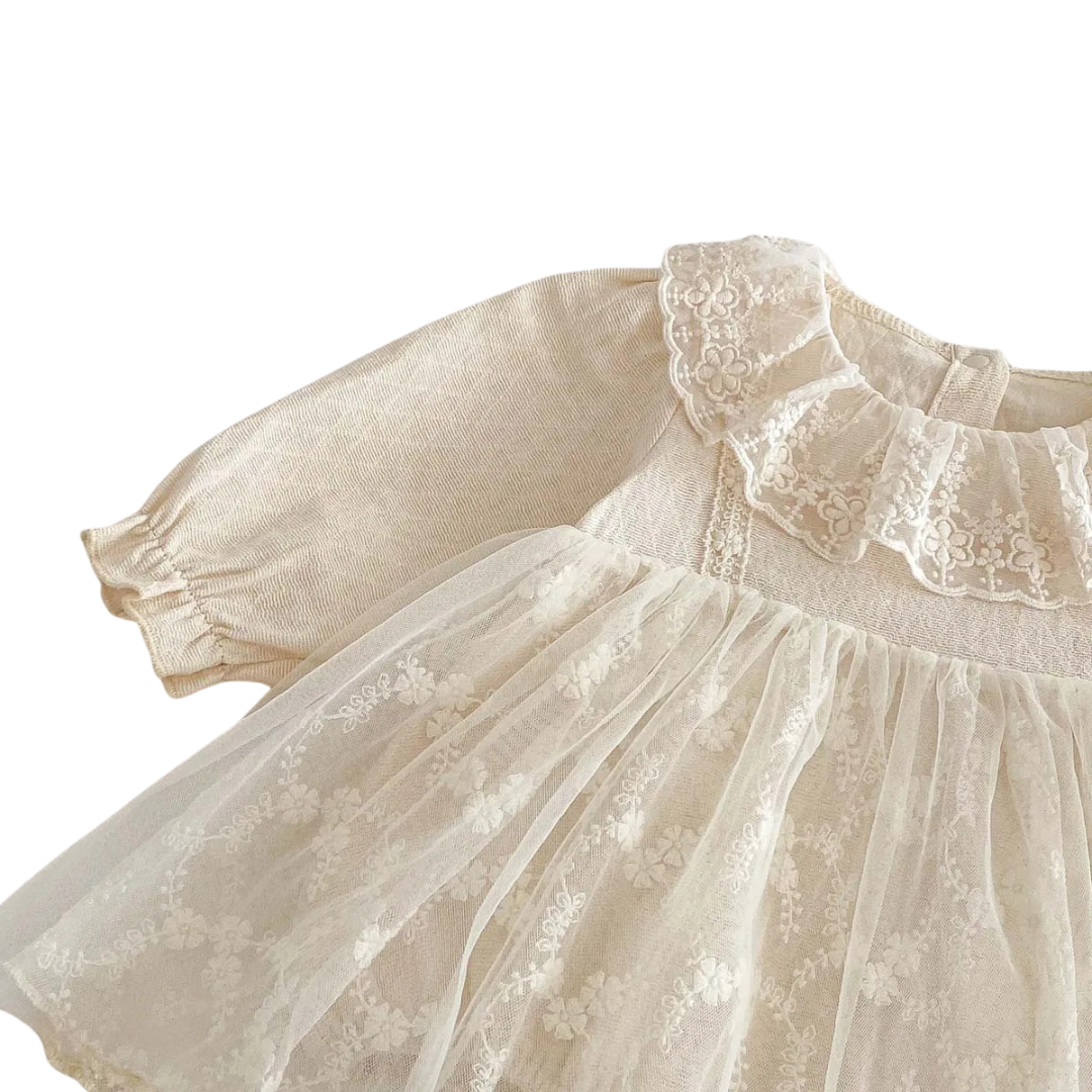 Angled close-up of the baby girl long-sleeve dress highlighting the vintage lace collar and textured cotton shoulder.