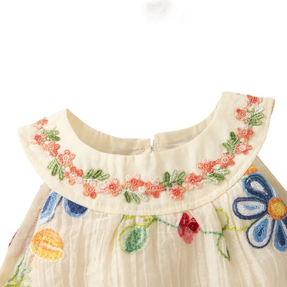 Close-up of the round neckline showing the intricate pink and green floral embroidery on the collar of the toddler dress.