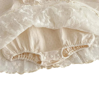 Underside view of the baby girl lace dress lifting the tulle skirt to reveal the attached built-in cotton bloomer bodysuit.