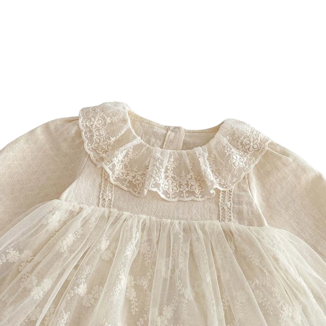 Close-up of the delicate ruffled lace collar and textured diamond dobby cotton bodice on the baby girl dress.