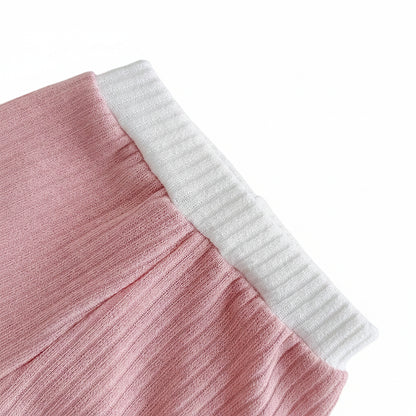 Close-up detail of the easy-on elastic waistband on the dusty rose ribbed knit baby shorts with white contrast trim detailing.