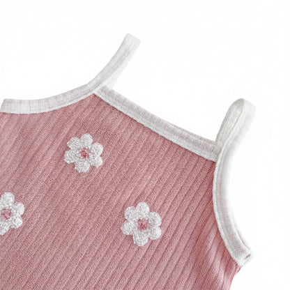 Close-up of the scoop neckline and shoulder strap on the dusty rose ribbed knit tank top, showing a white contrast trim and textured 3D floral appliqués.