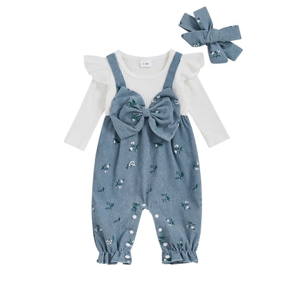 Slate blue floral corduroy baby girl overall romper featuring a front bow and a matching headband on a white background.