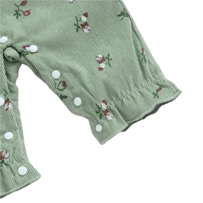 Close-up of the ruffled ankle cuffs and crotch snap button closures on the sage green baby romper.