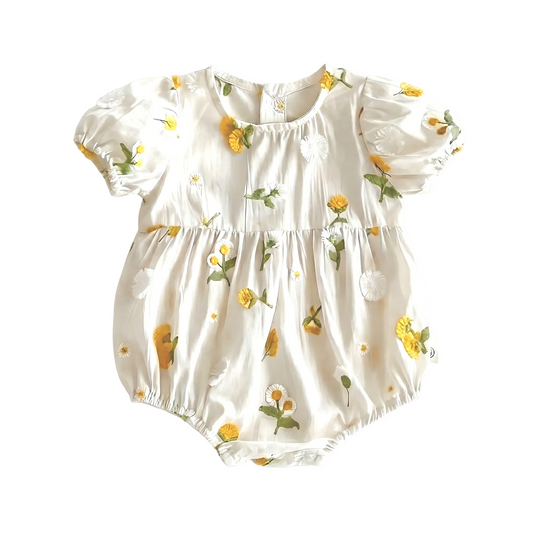 Flat lay photography of white cotton baby girl romper featuring 3D yellow floral embroidery and short puff sleeves on a white background.