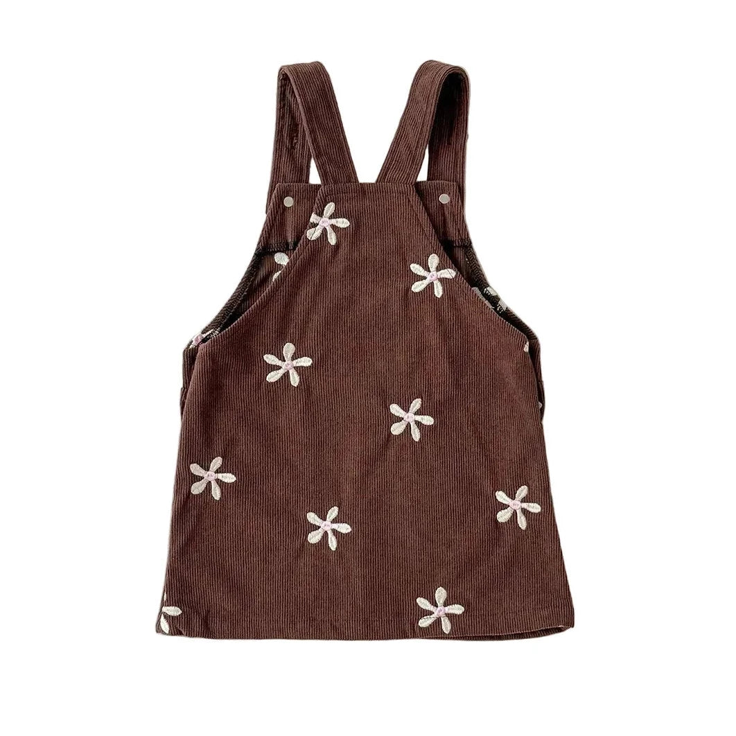 Back view showing shoulder straps and floral embroidery details on the brown corduroy dress.