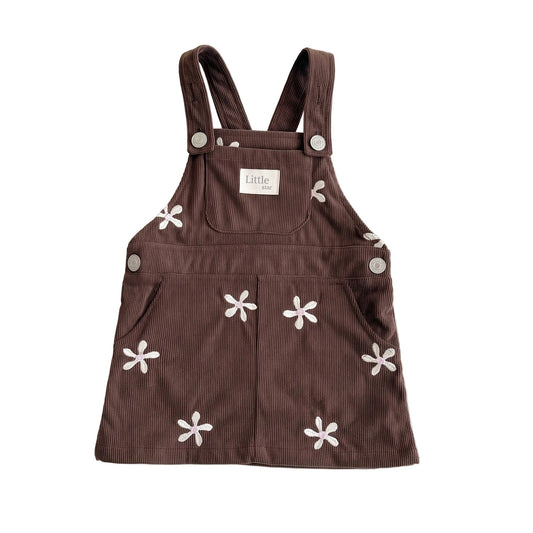 Front view of baby and toddler girls brown corduroy overall dress with white floral embroidery on a plain white background.
