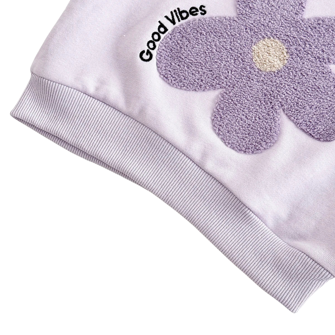Detail view of lavender baby sweatshirt ribbed sleeve cuff and Good Vibes flower print