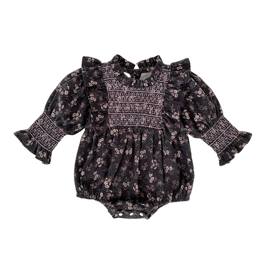 Baby girl grey floral smocked long sleeve romper with ruffle shoulders and elastic sleeve cuffs laid flat.