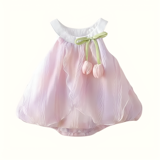 Pastel pink easter baby dress with a green bow and tulips on a white background
