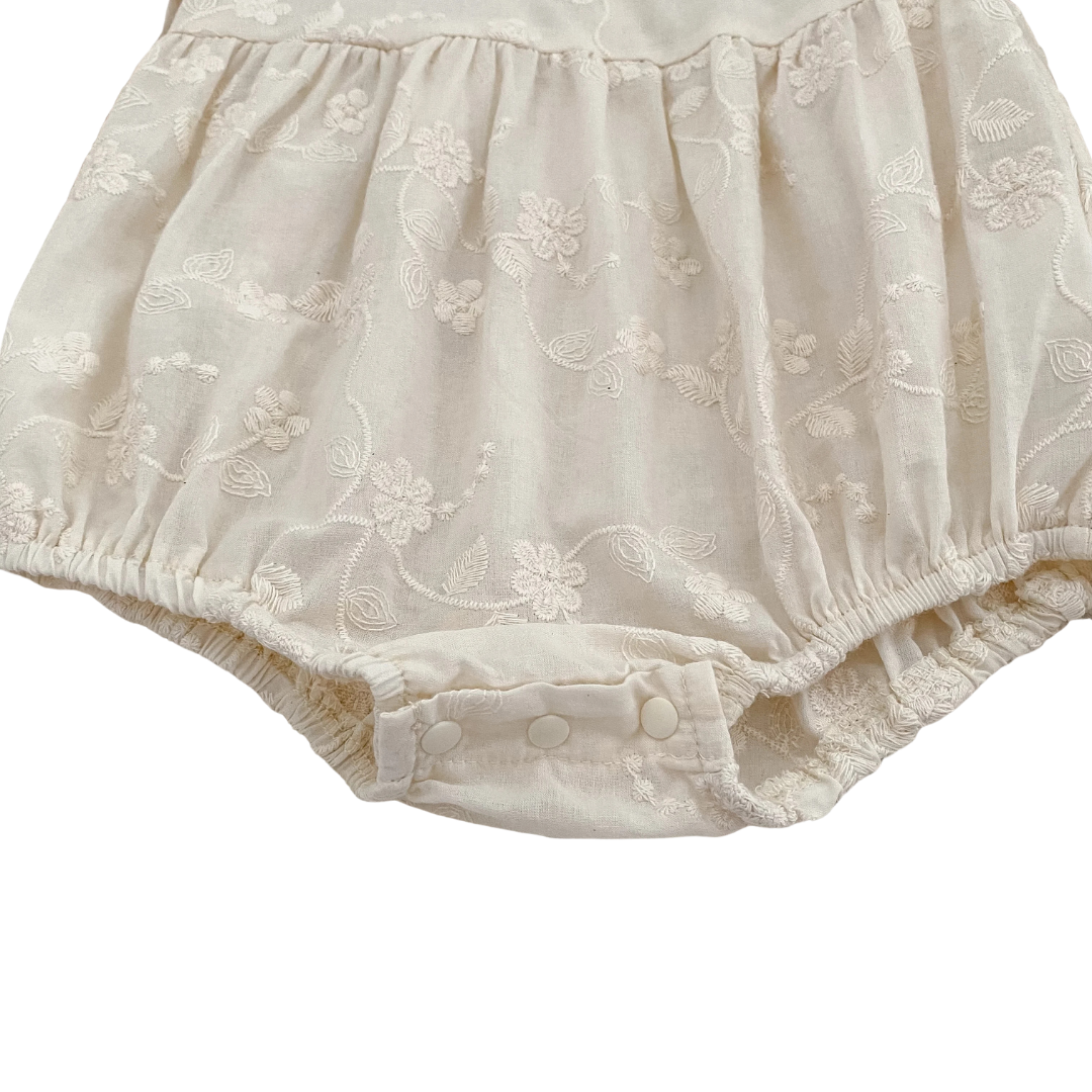 Close-up of gathered elastic leg opening on baby girl ivory cottagecore bubble romper.