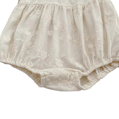 Close-up of gathered elastic leg opening on baby girl ivory cottagecore bubble romper.