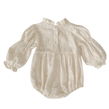 Back view of baby girl ivory floral embroidered bubble romper showing back button closure and high collar.