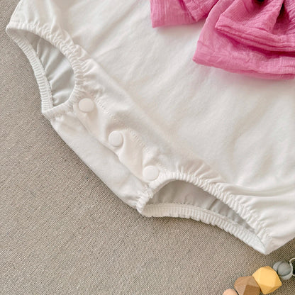 Detailed shot of the bottom of the white baby romper showing the three secure plastic snap closures and elastic leg openings.