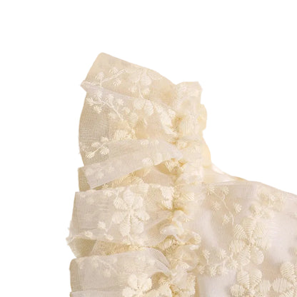 Close-up detail of delicate ruffle sleeve and layered floral lace fabric on cream romper