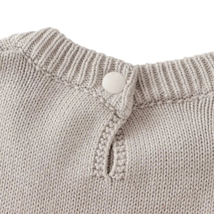 Close-up of the fastened button closure on the back neckline of the light gray knit dress.