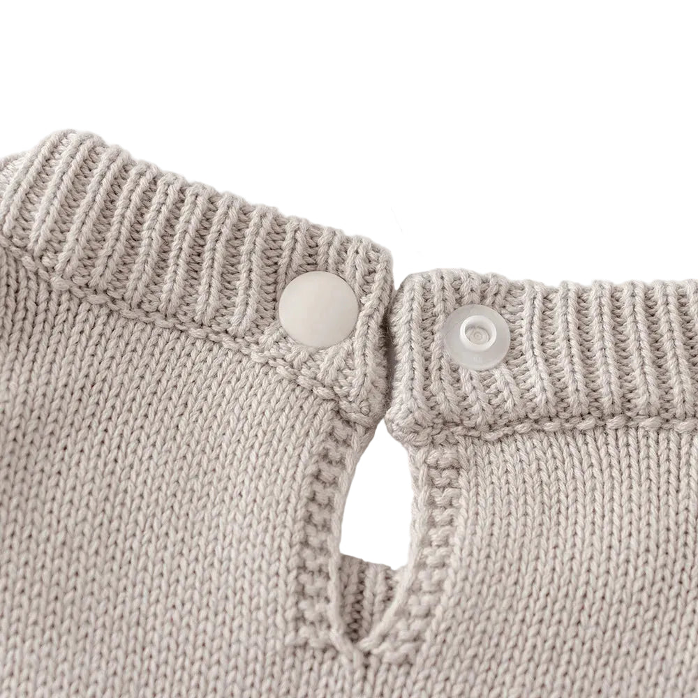 Close-up of the unbuttoned back neckline closure on the light gray knit baby dress.