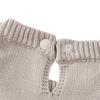Close-up of the unbuttoned back neckline closure on the light gray knit baby dress.