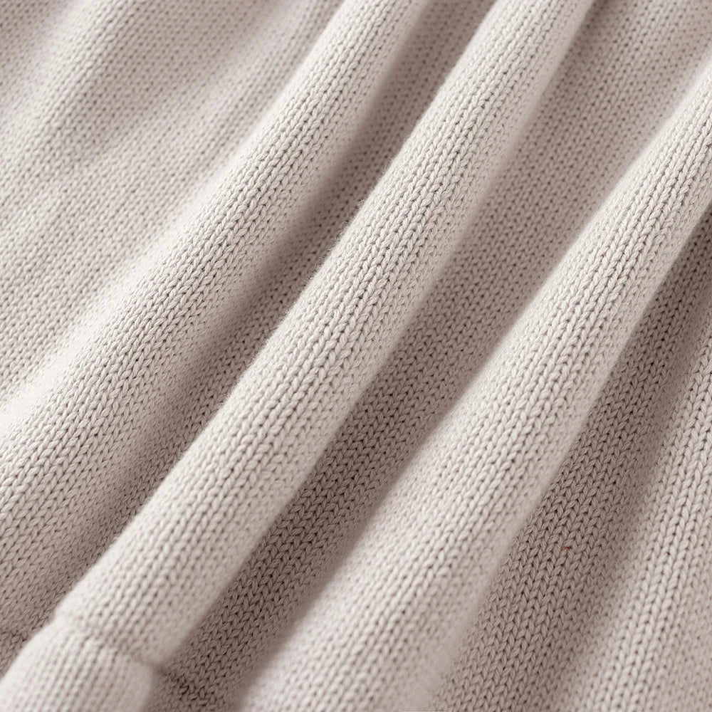 Close-up showing the soft, ribbed knit fabric texture and folds of the light gray sweater dress.