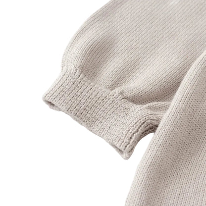 Close-up of the ribbed knit sleeve cuff on the light gray baby sweater dress.