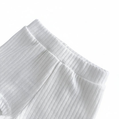 Close-up view highlighting the stretchy, enclosed elastic waistband construction on the marshmallow white ribbed baby shorts.