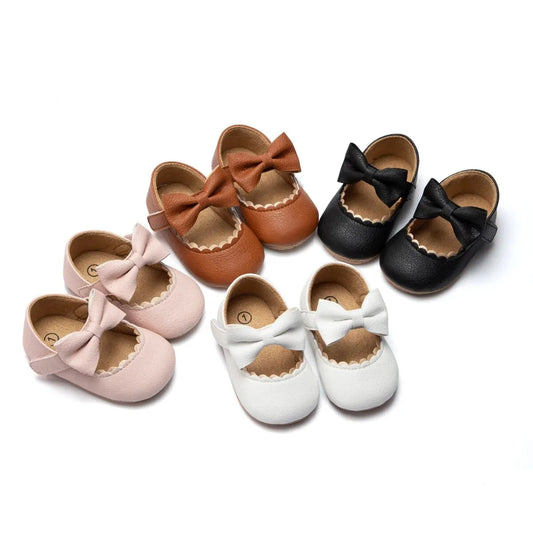 Collection of Baby Girl Mary Jane Dress Shoes in Soft Pink, Ivory White, Classic Black, and Dark Brown with bowknot detail and non-slip soles.