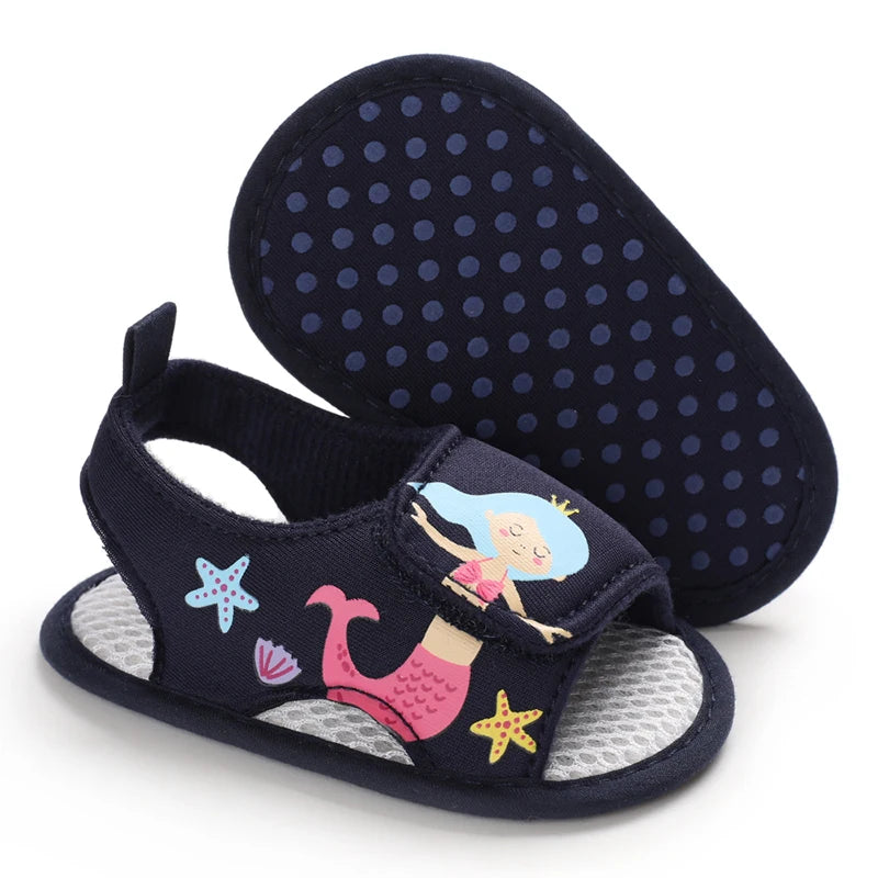 Bottom view of navy blue baby girl mermaid sandals showing the anti-slip dotted grip sole.