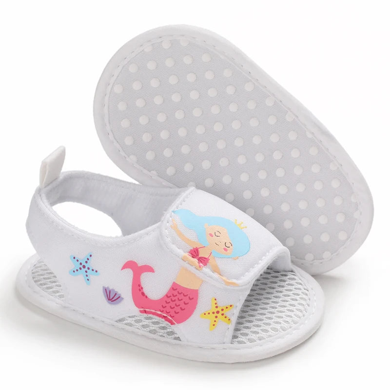 Bottom view of white baby girl mermaid sandals showing the anti-slip dotted grip sole.