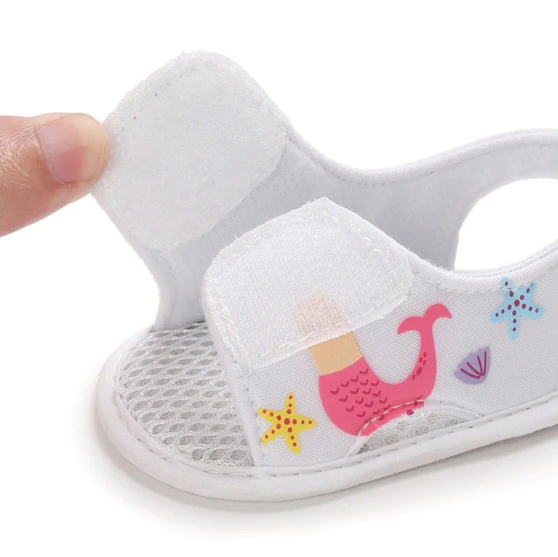 White baby girl mermaid sandal showing the open hook-and-loop velcro strap.