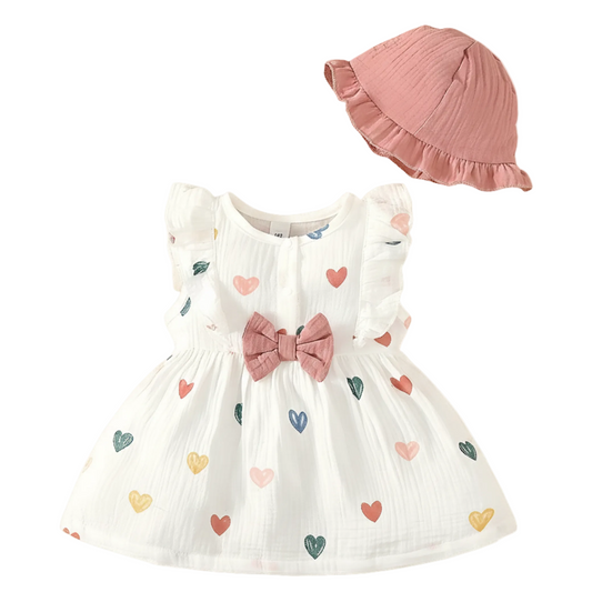 Baby Girl White dress with colorful heart patterns and a pink bow, paired with a matching pink hat on a white background.