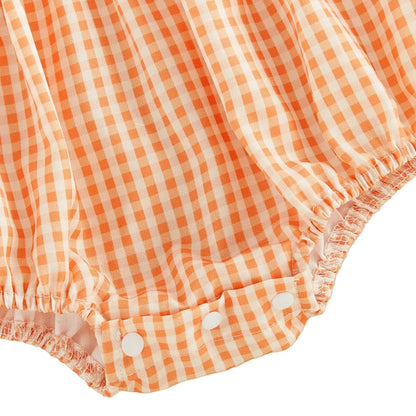 Close-up of the bottom snap closures and gathered elastic leg openings on the orange gingham baby bubble romper.