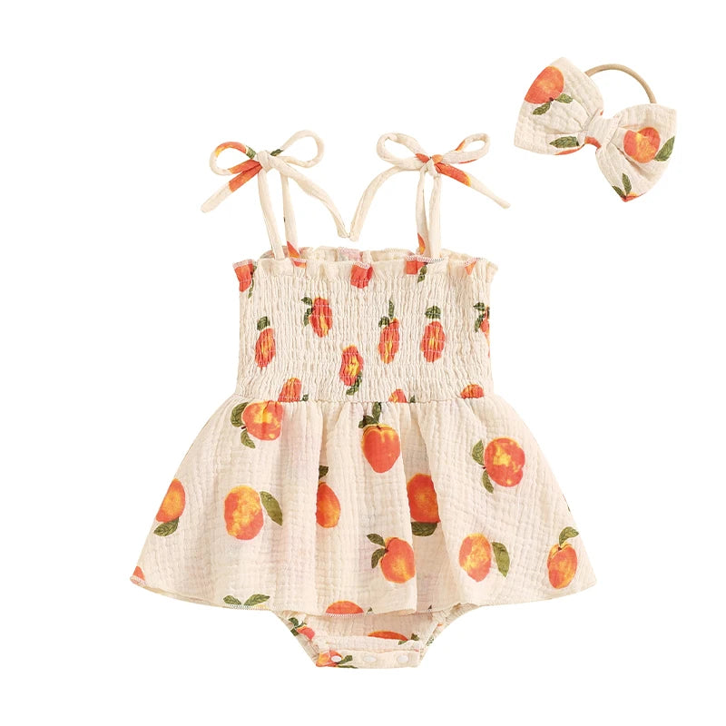 Baby girl peach print smocked romper dress and matching bow headband set on a white background.
