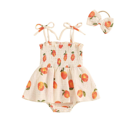 Baby girl peach print smocked romper dress and matching bow headband set on a white background.