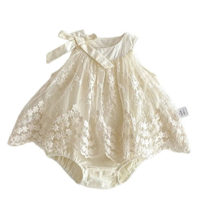 Flat lay of a baby girl sleeveless princess romper dress in Pearl Ivory featuring intricate floral lace embroidery, a decorative shoulder bow, and a built-in cotton bodysuit on a clean white background.