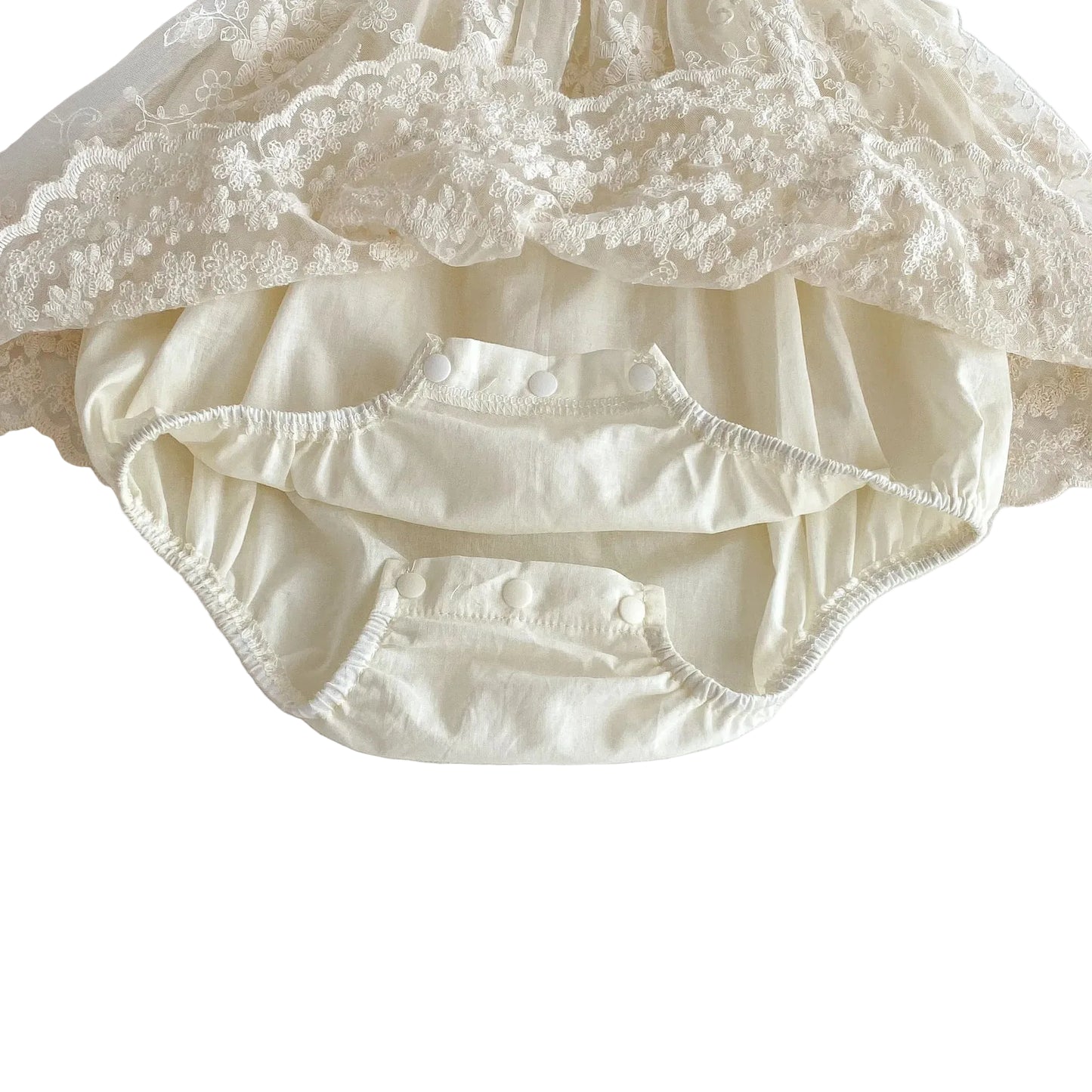 Close-up view of the open triple-snap bottom closure on the built-in cotton bodysuit for easy diaper changes.