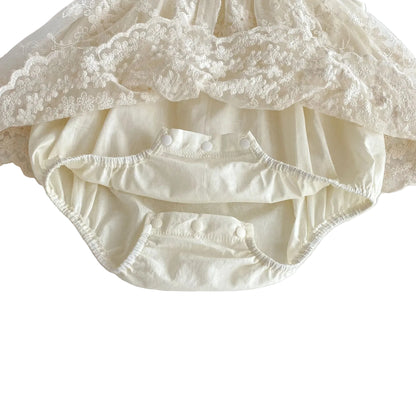 Close-up view of the open triple-snap bottom closure on the built-in cotton bodysuit for easy diaper changes.