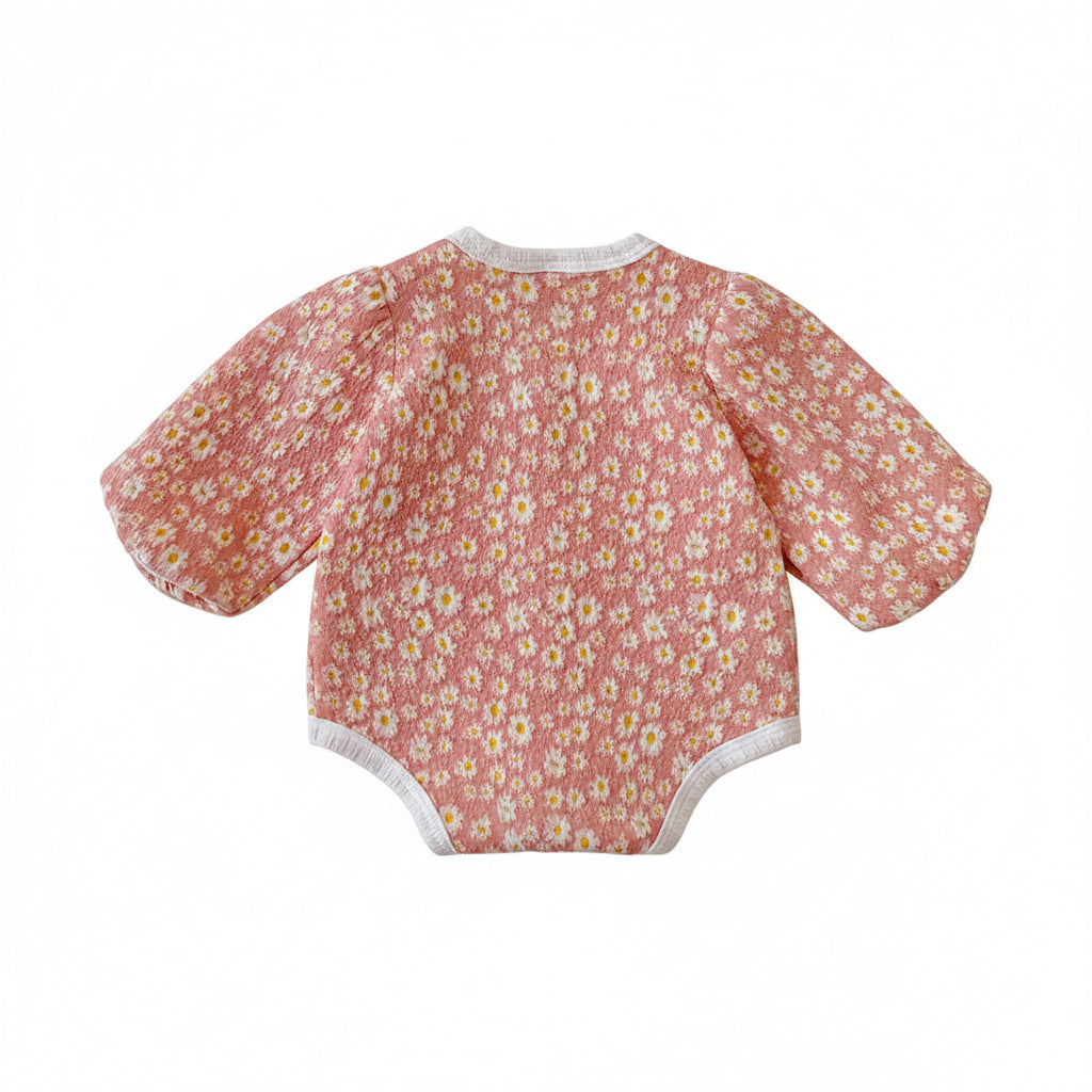 Back view of the baby girl pink daisy floral long sleeve bubble romper laid flat on a white background.